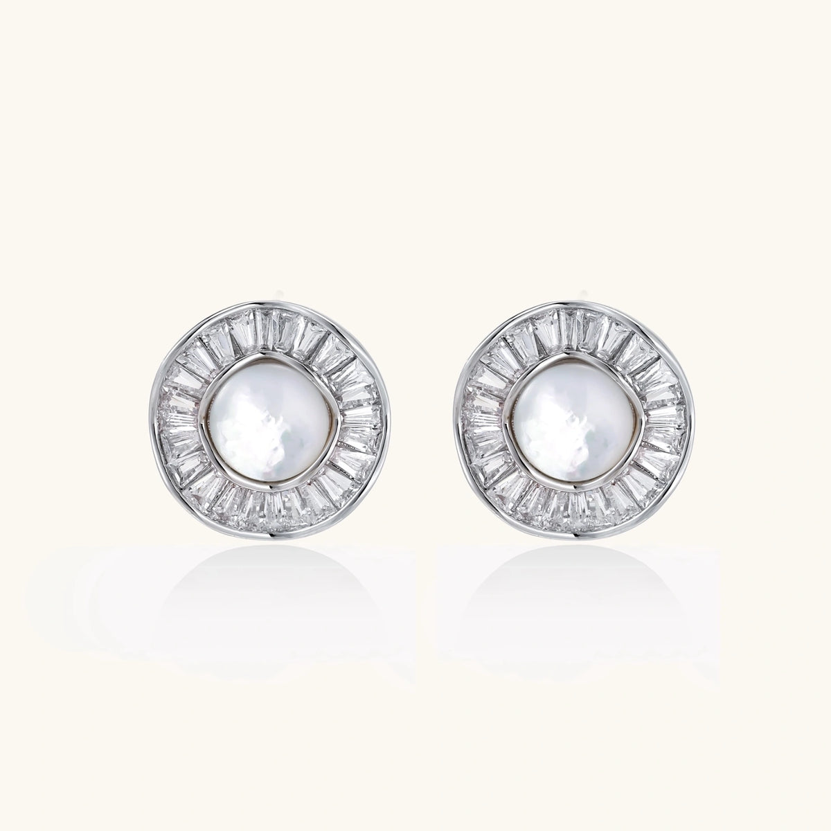 White gold-plated stud earrings with iridescent pearl centers surrounded by baguette crystal halos on white background.